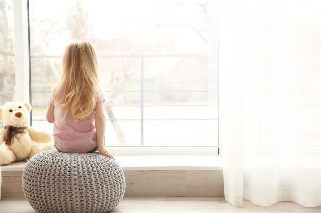 gallery Small girl sitting on ottoman near window