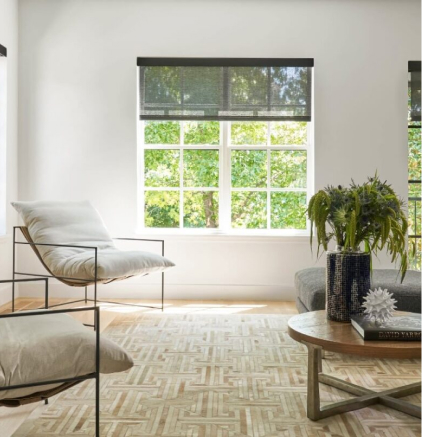 Gallery Modern living room with minimalist white cushioned chairs, large window, wooden table with plants and decor.
