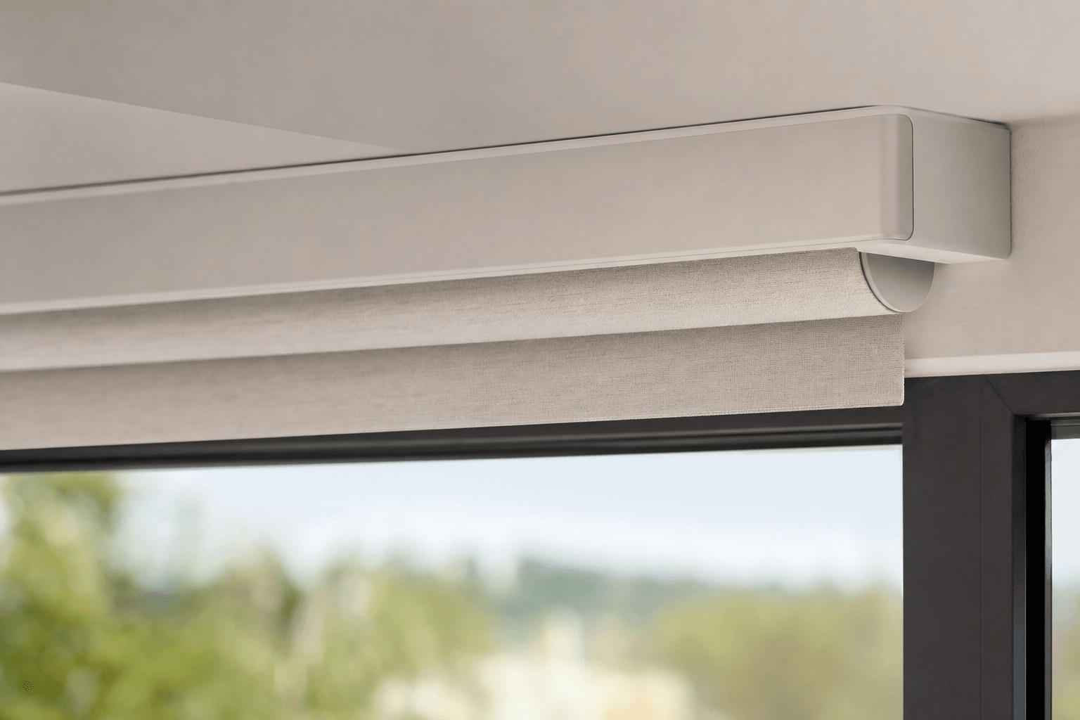 Close-up of a cordless motorized shade headrail mounted on a large picture window