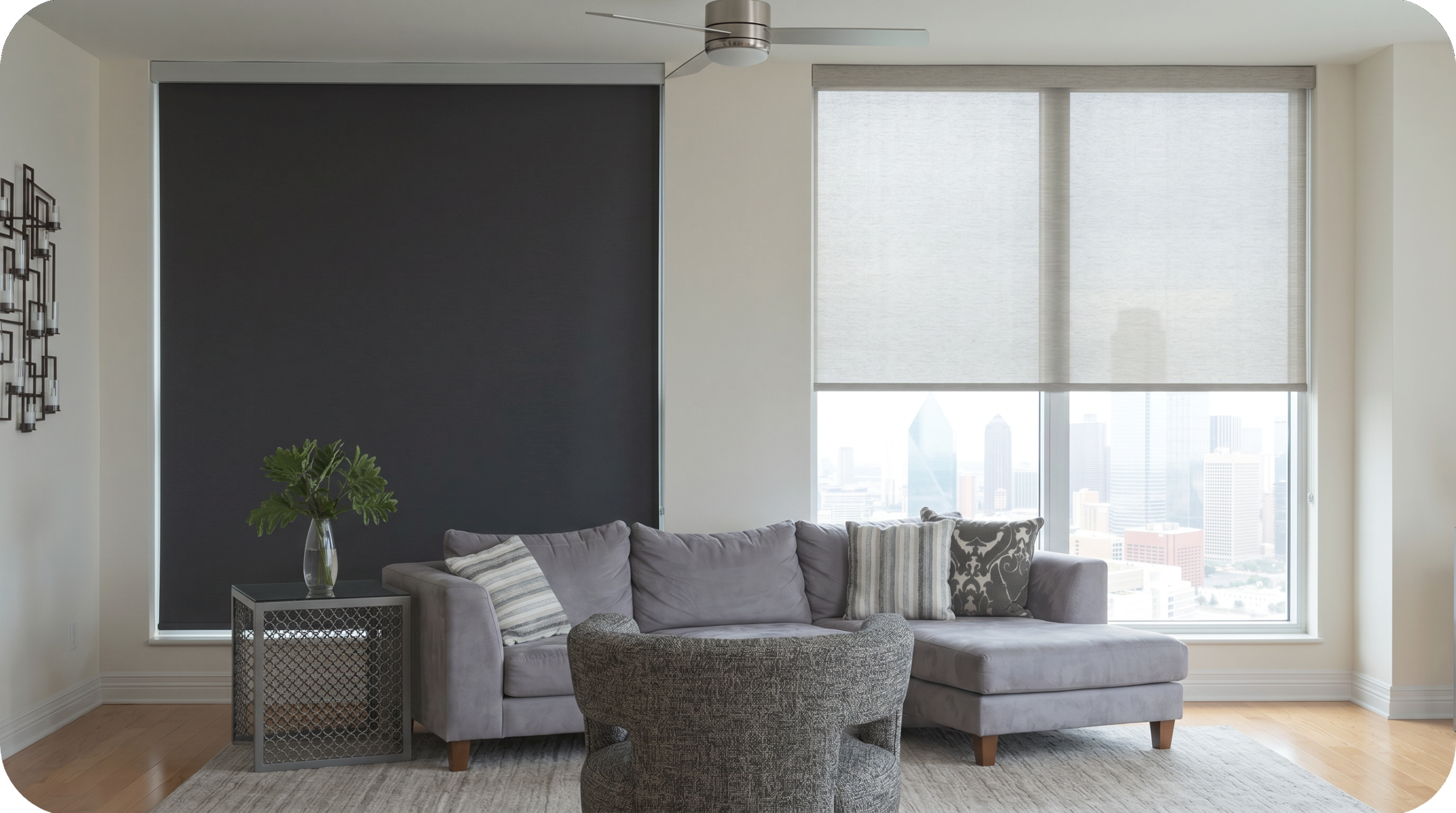 A blackout roller shade darkening one window next to a light-filtering roller shade glowing softly in a bright living room