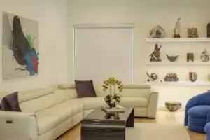 A Colourvue room-darkening roller shade installed inside a living-room window