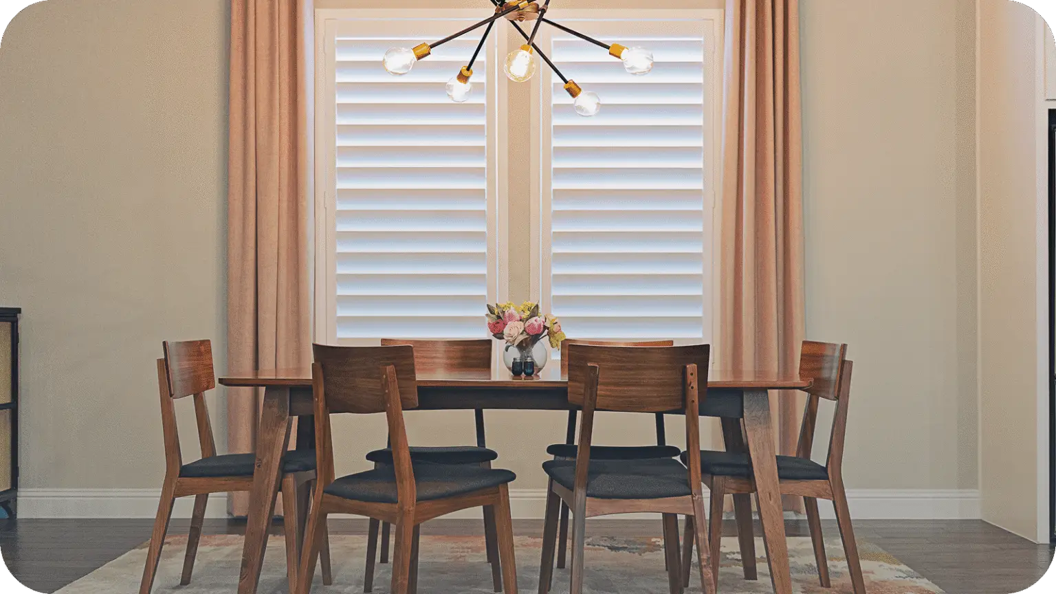 A Dallas dining room dressed with white plantation shutters and floor-length drapery