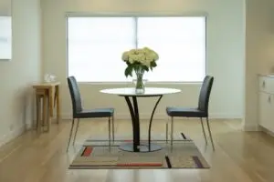 Two light-filtering Colourvue roller shades installed above a modern dining area