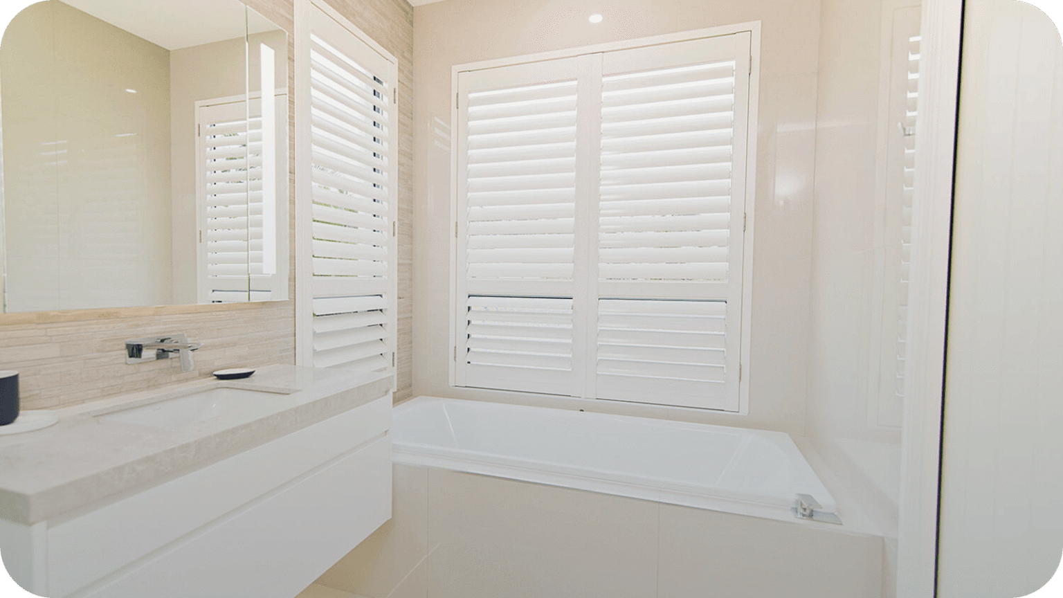 White plantation shutters in a bright bathroom, a moisture-resistant choice for humid rooms