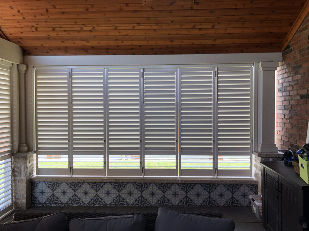 White Weatherwell Elite aluminum shutter panels enclosing a covered residential patio