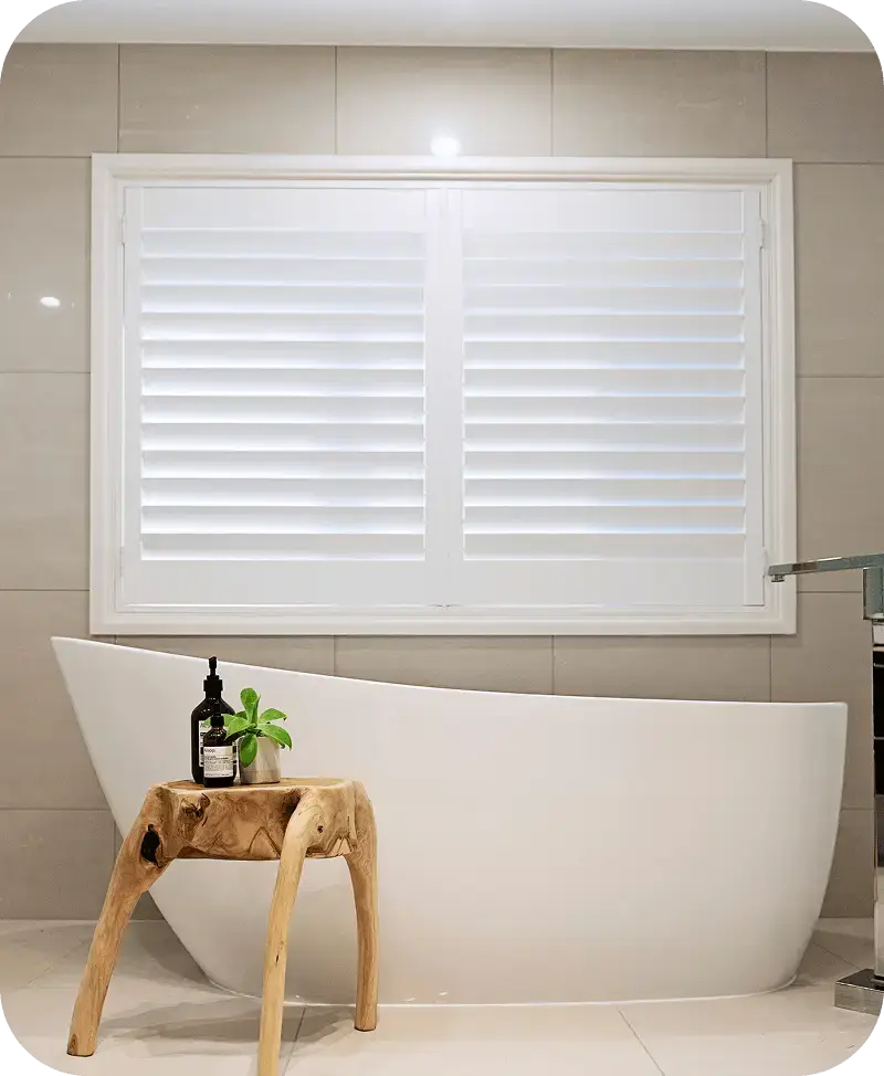 White Composition Poly shutter installed above a modern freestanding bathtub