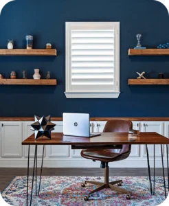 White hardwood painted shutter installed over an office window against a deep blue wall